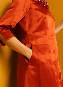 Orange, röd glansig festklänning. Knälång klänning med ärm. K&US Kandus unik svensk design