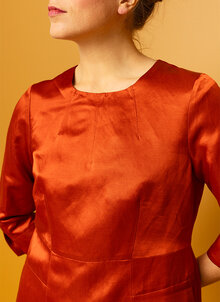 Orange, röd glansig festklänning. Knälång klänning med ärm. K&US Kandus unik svensk design