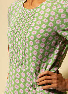 Kortärmad klänning med rosa blommor på grön botten. Kort ärm, plisserade detaljer. K&US