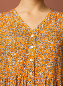Orange småblommig ullklänning i ledig form. Knappar fram. K&US Kandus svensk design