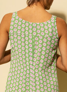 Söt ärmlös klänning med rosa blommor på grön botten. Liten volang nedtill, längd över knät, breda axelband. K&US design